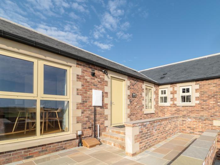 Byre Cottage in Embleton, Northumberland. Single-storey. Child-friendly. Spacious patio with hot tub