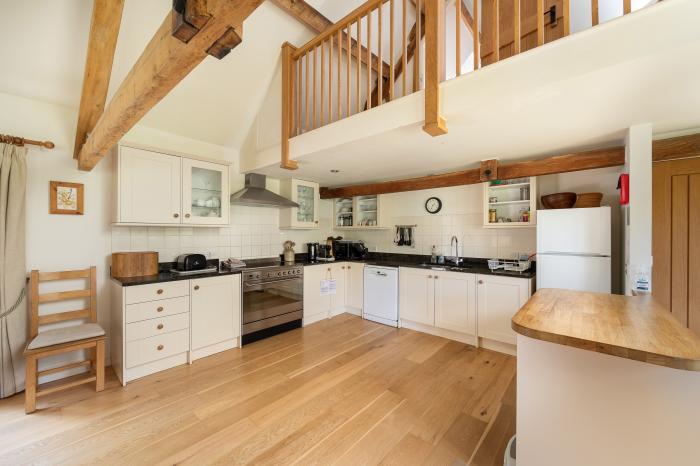 The Long Barn, is near Tetbury, in Gloucestershire. Eight-bedroom barn conversion set in AONB. Pets.