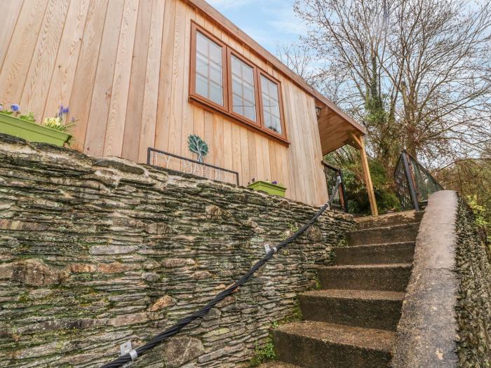 Ty Barddu near Newcastle Emlyn in Carmarthenshire. Elevated, wooden-clad cottage nestled in a valley